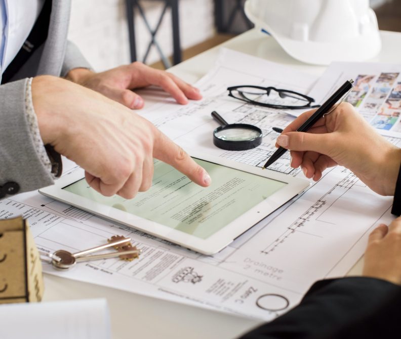 businessmen-analyzing-business-plan-tablet