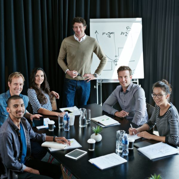 Portrait, group and happy business people in meeting for coworking, about us or collaboration in startup presentation. Face, team and creative workers together writing notes with financial advisor.