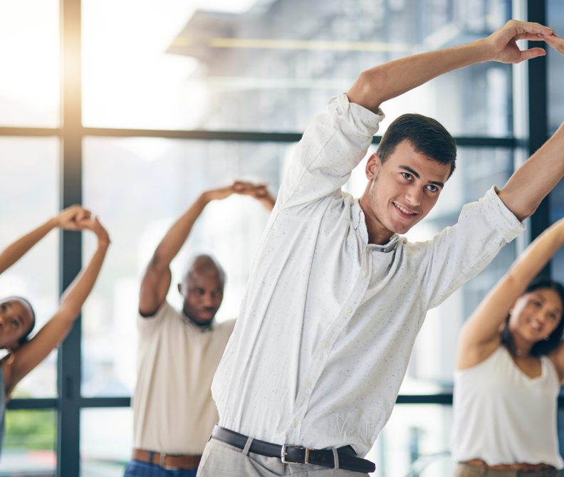 Team building, stretching and a team of business people in the office to workout for health or mobility together. Exercise, fitness and training with an employee group in the workplace for a warm up.